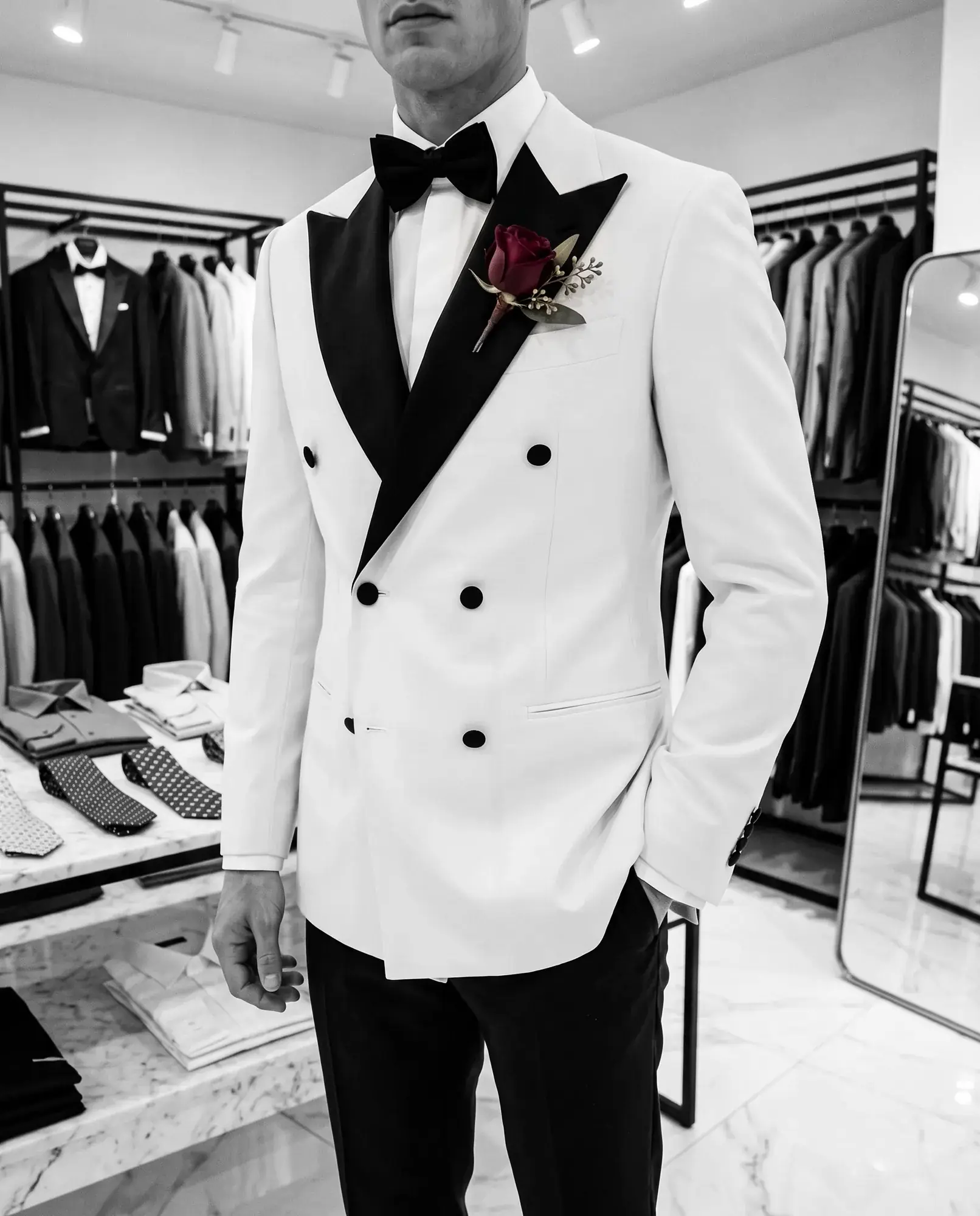 A groom in an ivory tuxedo jacket and black bow tie